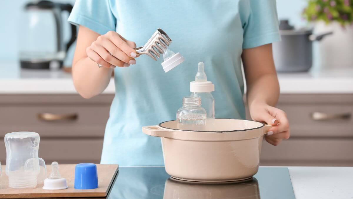 Parent sterilising bottles in boiling water